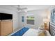 Bedroom with ceiling fan, window and wood dresser with modern lamp at 1291 Jonesville Ter, The Villages, FL 32162