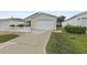 Exterior shot of a home featuring a two-car garage and a well-maintained lawn at 1291 Jonesville Ter, The Villages, FL 32162