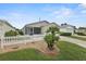 Charming home featuring a well-maintained front yard with a white picket fence and lush lawn at 1291 Jonesville Ter, The Villages, FL 32162
