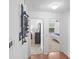 Hallway leads to bedrooms with neutral walls and carpet, plus an artistic wall hanging at 1291 Jonesville Ter, The Villages, FL 32162
