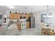 Bright kitchen features wood cabinets, stainless steel refrigerator, and white appliances at 1291 Jonesville Ter, The Villages, FL 32162
