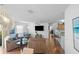 Bright open concept living space with hardwood floors, TV, seating, and modern decor at 1291 Jonesville Ter, The Villages, FL 32162