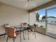 Covered patio featuring a round table, wicker chairs, and screened windows overlooking the yard at 1291 Jonesville Ter, The Villages, FL 32162