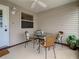 A screened in porch with ceiling fan and a glass table with four cushioned chairs at 1291 Jonesville Ter, The Villages, FL 32162