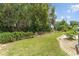 Lush green backyard with a fence line and mature trees providing privacy at 1303 E Schwartz Blvd, Lady Lake, FL 32159