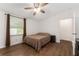 Bright bedroom featuring wood-look floors, ceiling fan, and a window with light brown curtains at 1303 E Schwartz Blvd, Lady Lake, FL 32159