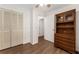 Bright bedroom featuring wood-look floors, white closet doors, and a built-in bookcase at 1303 E Schwartz Blvd, Lady Lake, FL 32159