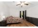 Bright bedroom featuring wood-look floors, ceiling fan, and a window with black curtains for a modern touch at 1303 E Schwartz Blvd, Lady Lake, FL 32159