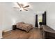 Bedroom with wood-look floors, ceiling fan, natural light, and dark colored nightstand and dresser at 1303 E Schwartz Blvd, Lady Lake, FL 32159