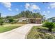 Single-story home featuring well-maintained landscaping and a concrete driveway at 1303 E Schwartz Blvd, Lady Lake, FL 32159
