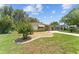 Charming front yard with manicured landscaping, a well-maintained lawn, and a paved driveway at 1303 E Schwartz Blvd, Lady Lake, FL 32159