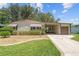 Charming single-story home with mature landscaping, well-maintained lawn, and attached garage and carport at 1303 E Schwartz Blvd, Lady Lake, FL 32159