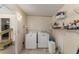 A functional laundry room equipped with a washer, dryer, and storage shelves at 1303 E Schwartz Blvd, Lady Lake, FL 32159