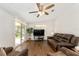 Living room with wood floors, sliding glass door, ceiling fan, and comfortable seating at 1303 E Schwartz Blvd, Lady Lake, FL 32159
