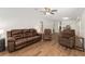 Open-concept living room featuring wood floors, comfortable seating, and access to the kitchen at 1303 E Schwartz Blvd, Lady Lake, FL 32159