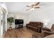 Living room with wood floors, ceiling fan, and sliding glass doors leading to the outdoor patio at 1303 E Schwartz Blvd, Lady Lake, FL 32159
