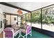 A screened porch with a table and four chairs overlooking a peaceful backyard at 1303 E Schwartz Blvd, Lady Lake, FL 32159