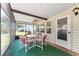 A screened porch with a table and four chairs overlooking a peaceful backyard at 1303 E Schwartz Blvd, Lady Lake, FL 32159