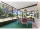A screened porch with a table and four chairs overlooking a peaceful backyard at 1303 E Schwartz Blvd, Lady Lake, FL 32159
