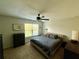 This bedroom features a ceiling fan, a black dresser, and a large window for natural light at 147 Aston Grande Dr, Daytona Beach, FL 32124