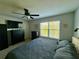 This bedroom features a ceiling fan and a large window with natural light and a dresser beneath a TV at 147 Aston Grande Dr, Daytona Beach, FL 32124