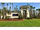 View of Grande Champions at LPGA International entrance with lush landscaping and mature palm trees under a clear blue sky at 147 Aston Grande Dr, Daytona Beach, FL 32124