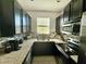 Stylish kitchen featuring granite countertops, a stainless steel sink, and dark cabinets at 147 Aston Grande Dr, Daytona Beach, FL 32124