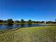 A beautiful view of the community pond on a bright sunny day, with the grassy shoreline in the foreground at 147 Aston Grande Dr, Daytona Beach, FL 32124