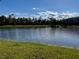 A beautiful view of the community pond on a bright sunny day, with the shoreline in the foreground at 147 Aston Grande Dr, Daytona Beach, FL 32124