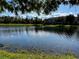 A beautiful view of the community pond on a bright sunny day, with a building in the background at 147 Aston Grande Dr, Daytona Beach, FL 32124