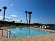 Community swimming pool with comfortable lounge chairs and palm trees in the distance at 147 Aston Grande Dr, Daytona Beach, FL 32124