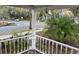 Charming front porch with white railings, offering a tranquil view of the street and surrounding greenery at 148 W 9Th Ave, Mount Dora, FL 32757