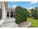 Backyard view of the screened-in lanai, private hedge, and manicured landscaping at 1521 Southport St, The Villages, FL 32162