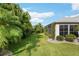 Spacious backyard featuring lush lawn, mature trees and landscaping for added privacy at 1521 Southport St, The Villages, FL 32162