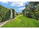Expansive backyard featuring lush lawn, mature trees and landscaping for privacy at 1521 Southport St, The Villages, FL 32162