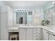Bright bathroom featuring a vanity with marble countertop and white cabinets, as well as a makeup vanity at 1521 Southport St, The Villages, FL 32162