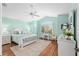 Stylish bedroom with vaulted ceiling, ceiling fan, large window, and wood floors at 1521 Southport St, The Villages, FL 32162