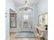 Bright entryway features decorative glass door, chandelier, tile floor, and elegant console table at 1521 Southport St, The Villages, FL 32162