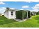Exterior view of a well-maintained home with mature landscaping and green lawn at 1521 Southport St, The Villages, FL 32162