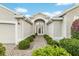 Attractive front entrance featuring manicured shrubs, a well-tended walkway, and neutral stucco siding at 1521 Southport St, The Villages, FL 32162