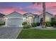 Charming single-story home featuring a lush, landscaped front yard and a convenient two-car garage at 1521 Southport St, The Villages, FL 32162