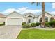 Charming single-story home featuring a lush, landscaped front yard and a convenient two-car garage at 1521 Southport St, The Villages, FL 32162