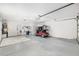 Spacious garage featuring a golf cart, overhead lighting, and ample room for storage and parking at 1521 Southport St, The Villages, FL 32162