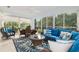 Sunroom featuring wicker furniture, a glass table, and expansive windows overlooking the landscaped outdoors at 1521 Southport St, The Villages, FL 32162