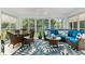 Bright sunroom with wicker seating, a leaf-patterned rug, and views of the lush backyard at 1521 Southport St, The Villages, FL 32162
