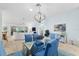 Bright and airy living area featuring a dining table with blue chairs and comfortable seating at 1521 Southport St, The Villages, FL 32162