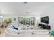 Cozy living room with a large sectional sofa, ceiling fan, and access to the outdoor patio at 1521 Southport St, The Villages, FL 32162