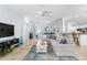 Bright living room with open floor plan, modern decor, and seamless flow into kitchen and dining areas at 1521 Southport St, The Villages, FL 32162