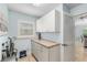 Well-lit utility room offers ample cabinet space, counter space, and a window at 1521 Southport St, The Villages, FL 32162