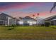 Enjoy the sunset while relaxing in this screened lanai surrounded by a green lawn and palm trees at 157 Julliard Blvd, Davenport, FL 33897